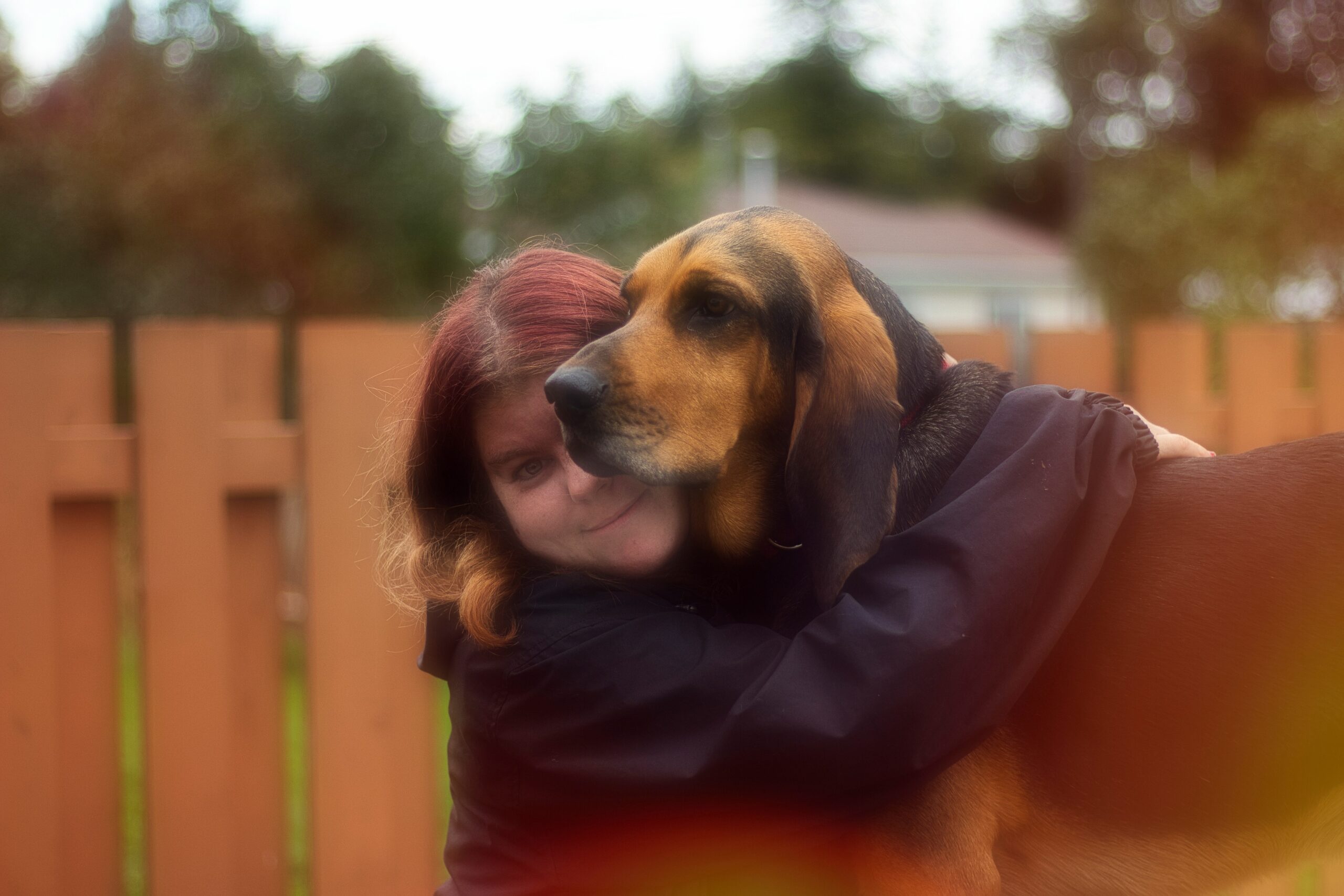 Photo of a happy dog owner hugging their pup after receiving test results