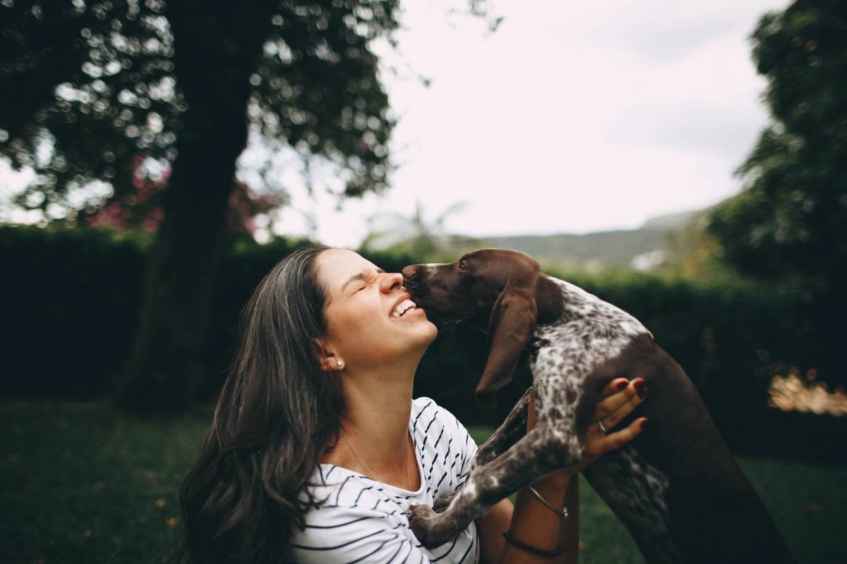 Photograph showing owner using hand signals while training her hearing-impaired dog
